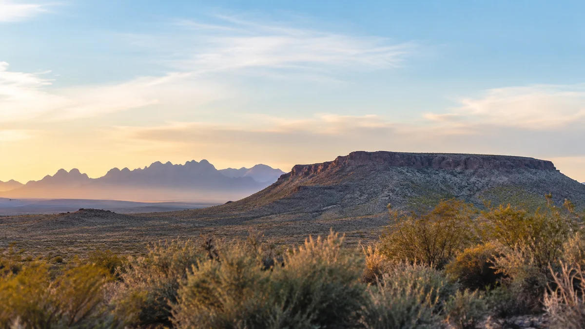 A calm high-desert plateau and the Organ Mountains near Las Cruces, NM at soft dawn light, a quiet metaphor for a weight-loss plateau